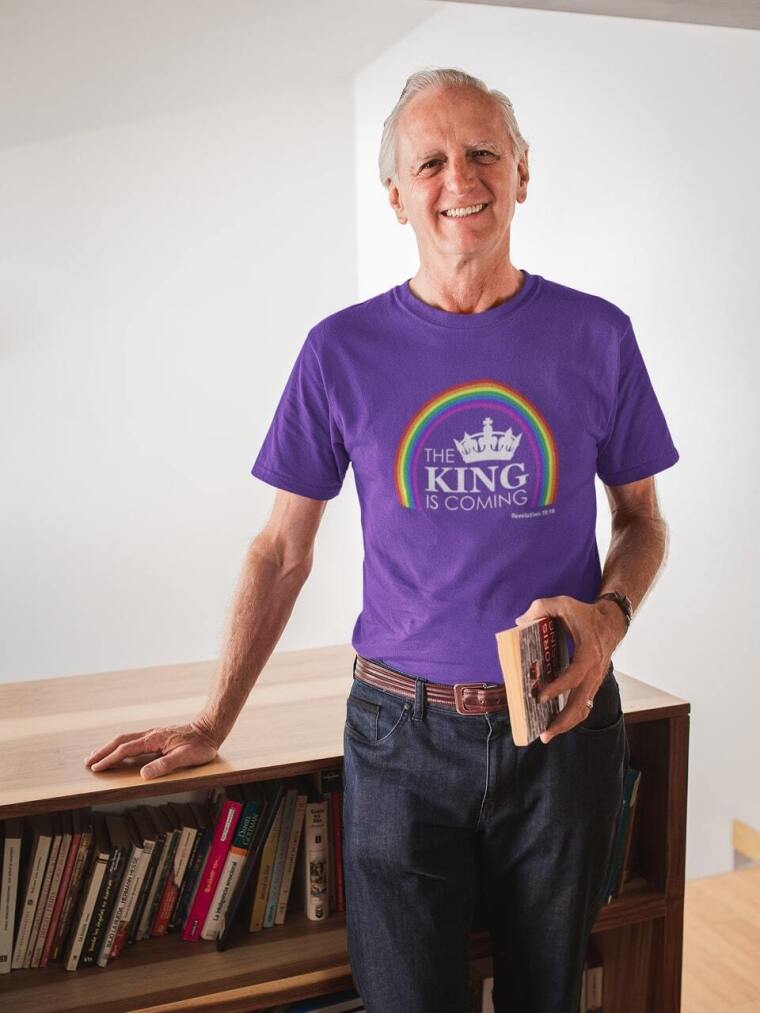 smiling-man-wearing-a-tshirt-mockup-holding-a-book-in-his-house-a20506